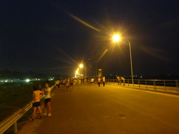 Promenáda při Mekongu je plná i po setmění.
